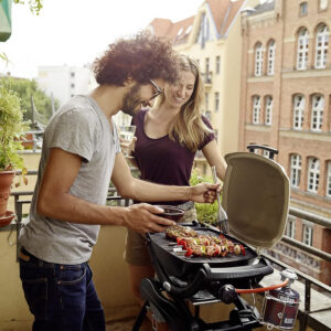 weber-q-1000-titan-auf-balkon-mit-personen-am-grillen