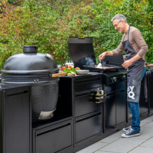 outdoorchef-kueche-mit-kamado-und-heat-grill-abgebildet-schwarz-und-einem-mann-der-grillt
